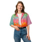 A model with light skin is wearing a colorful rainbow gradient button down shirt with jeans.