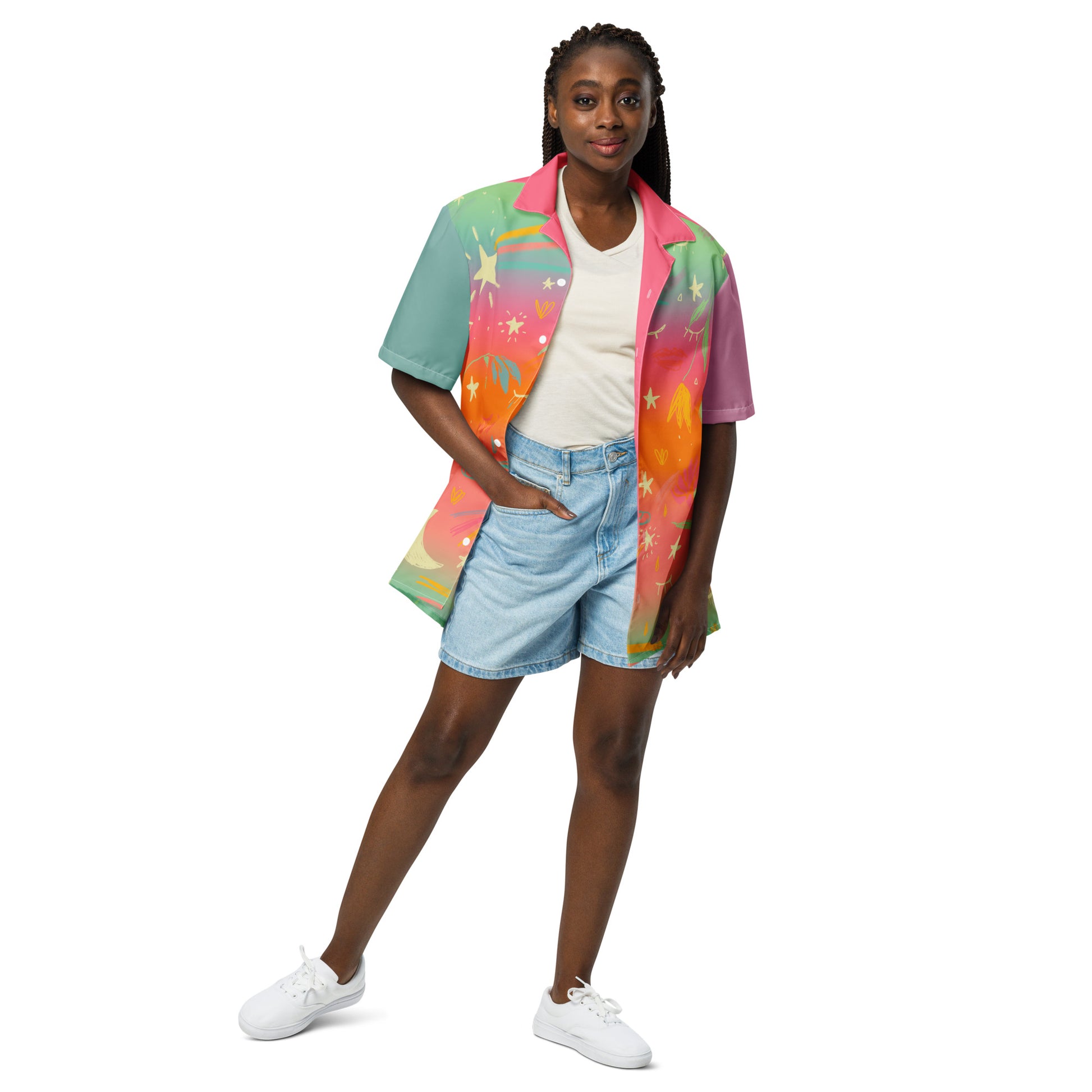 A model with brown skin is wearing a colorful rainbow gradient button down shirt.