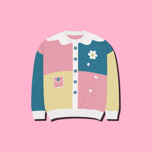 A pastel color-block sweater with a 2D collar, blue buttons, a pink pocket detail, and a white daisy graphic, shown on a solid pink background.